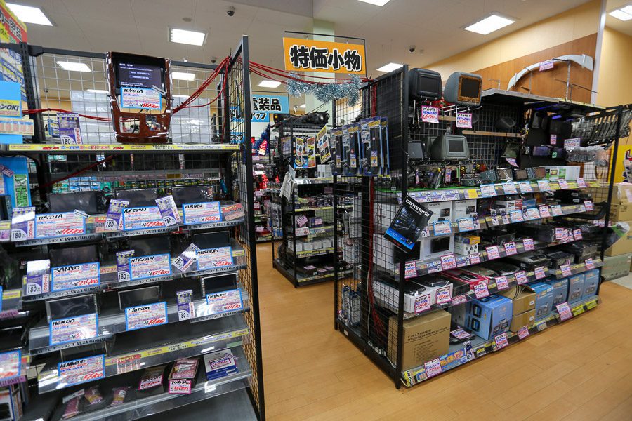 Electronics section in a Japanese store with various devices, accessories, and signs. Sign reads, Special Price Small Items.