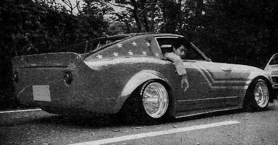 Vintage Japanese modified car with wide body kit and unique design parked on the street. Driver leans out of the window.