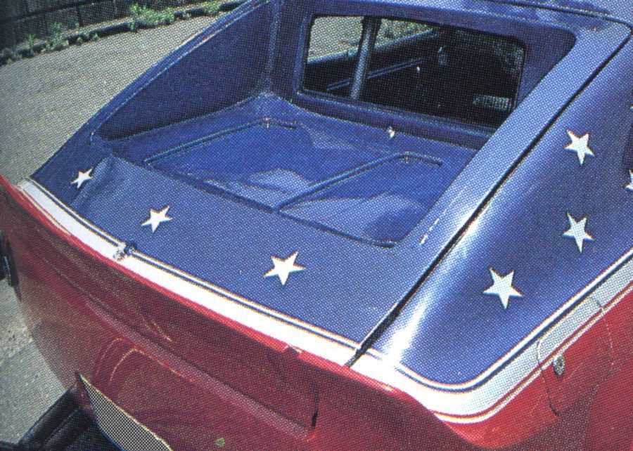Red and blue car with white stars painted on the trunk, showcasing a patriotic theme and unique design.