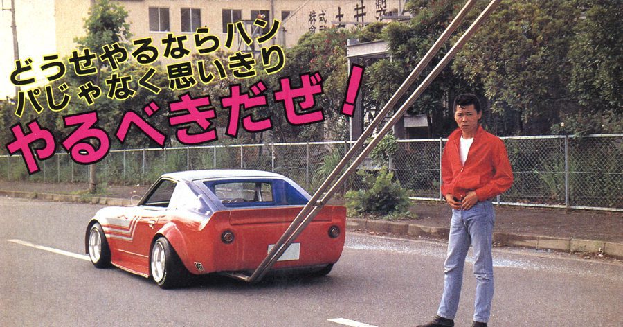 Man in red jacket standing next to a modified classic car in Japan with Japanese text saying If you do it, do it right!