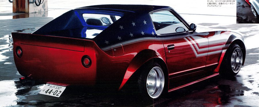 Custom red sports car with wide-body kit, American flag design, and Japanese license plate in an indoor setting.