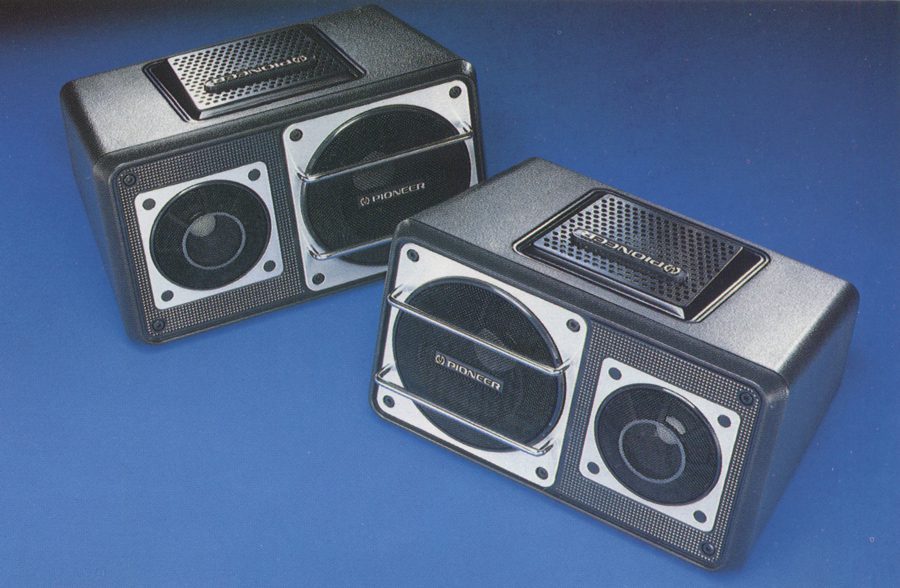 Two Pioneer TS-X11 vintage car speakers on a blue background, showcasing their retro design.