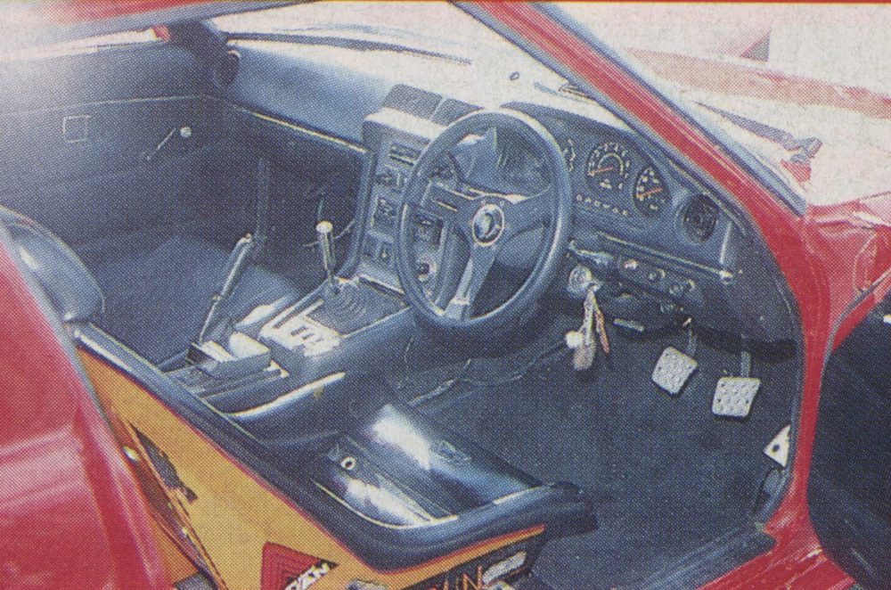 Interior of a red classic Japanese car featuring a black dashboard, steering wheel, and gear shift lever.