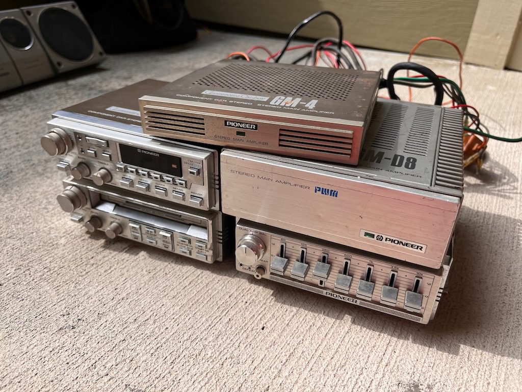 Vintage Pioneer car stereo system with GM-4 and GM-D8 amplifiers and multi-function controls on a beige background.