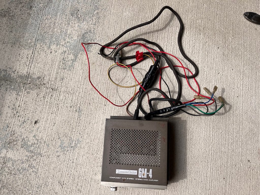 Vintage Lonesome Carboy GM-4 Component Car Stereo Main Amplifier with wires on a concrete surface.