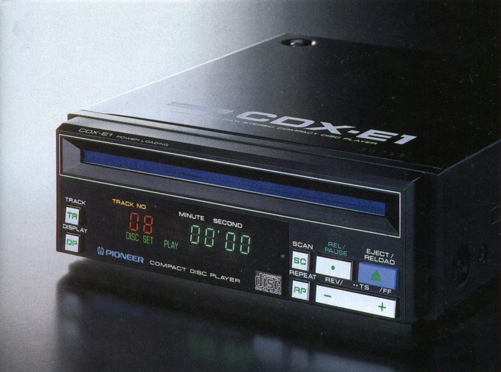 Alt text: Pioneer CDX-E1 compact disc player with digital display and controls for track, scan, repeat, and eject functions.