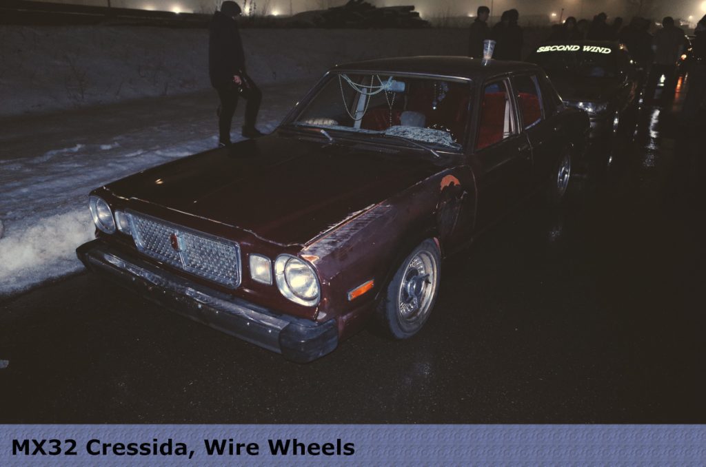 Vintage MX32 Cressida with wire wheels parked at night, adorned with Second Wind windshield text.