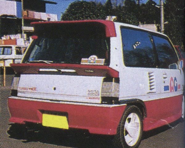 Customized white and red car with graphics parked on a street in Japan.