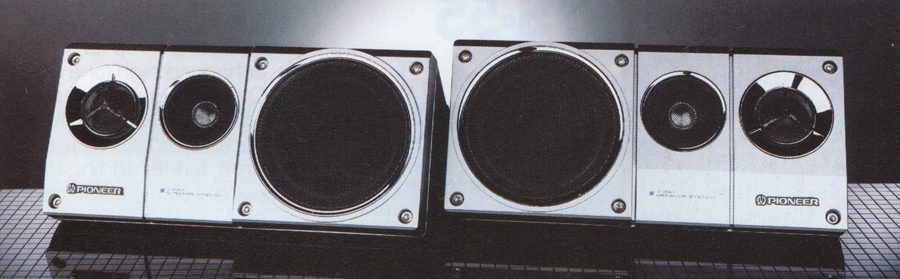 Alt text: Vintage Pioneer speakers with the text 'パイオニア (Pioneer)' on the front, placed on a checkered surface.