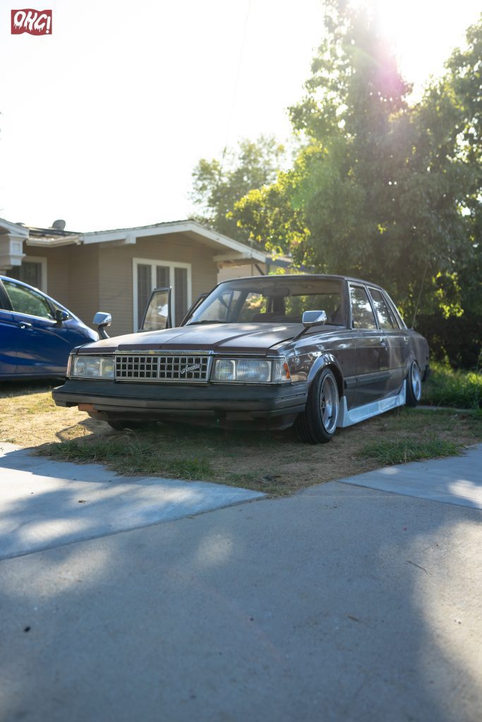 Vintage Toyota Crown parked in front of a house with アバンテ (Avante) badge on the grille, under a clear sky.