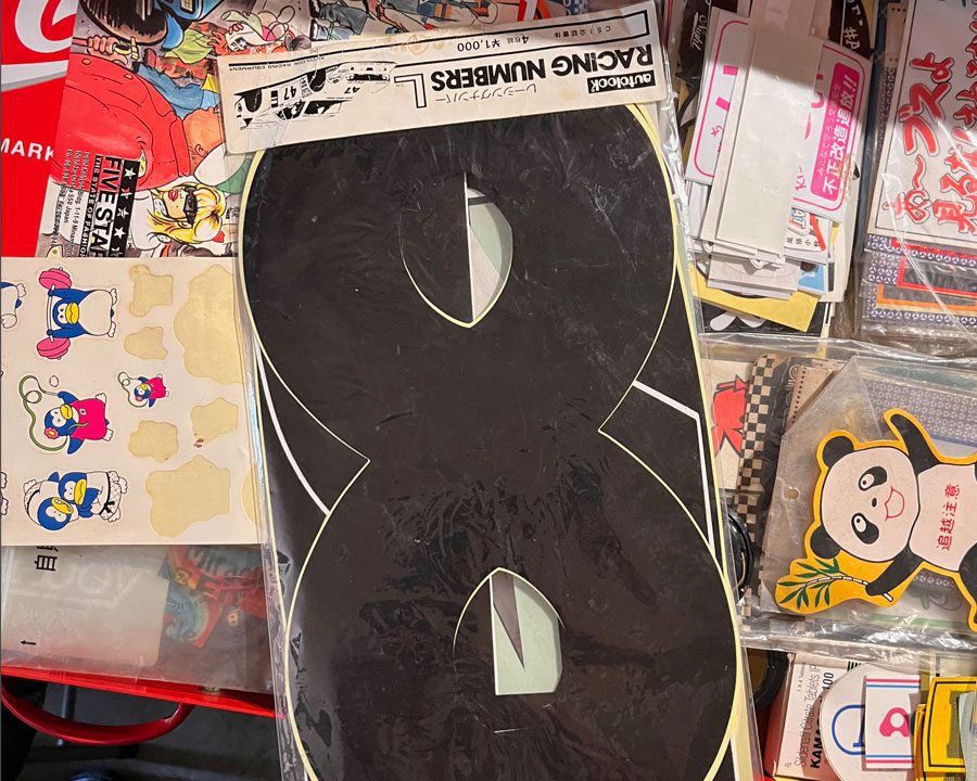 Assorted retro stickers, including a large black racing number 8, colorful penguin characters, and a cute panda.