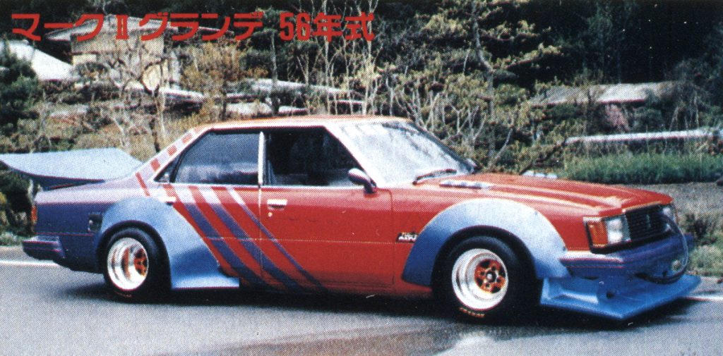 Red custom Mark II Grande 1981 model with unique blue decals and wide-body kit in a scenic outdoor setting.