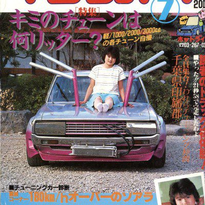 Japanese magazine cover of 'Young Auto' featuring a modified car with a woman sitting on the hood, July issue.