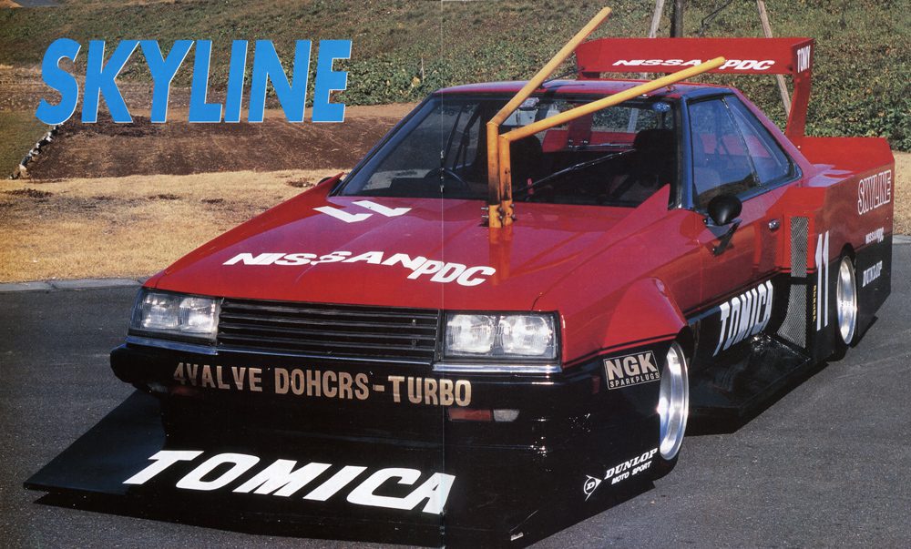 Red Nissan Skyline racing car with turbo modifications and Tomica branding on a track.